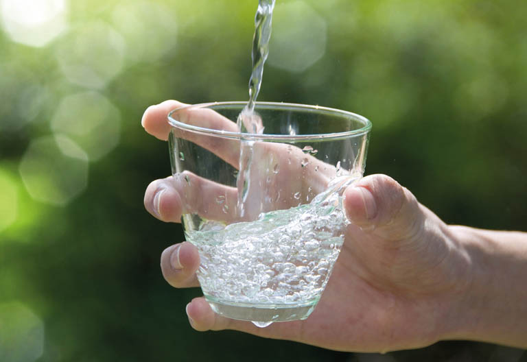 Glas wird mit Wasser befüllt