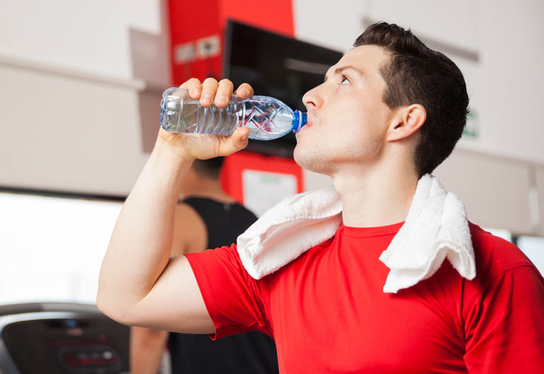 Mann trinkt aus Wasserflasche